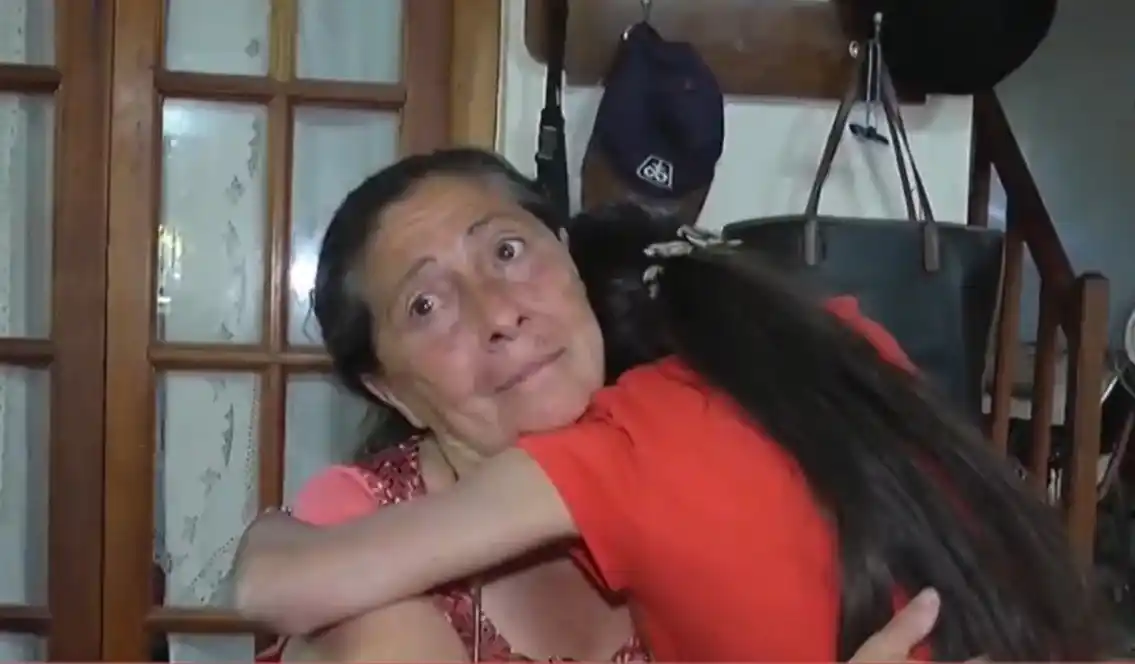 Maia, abrazada a su madre, aguarda que IOMA le entregue la medicación que necesita para su tratamiento.