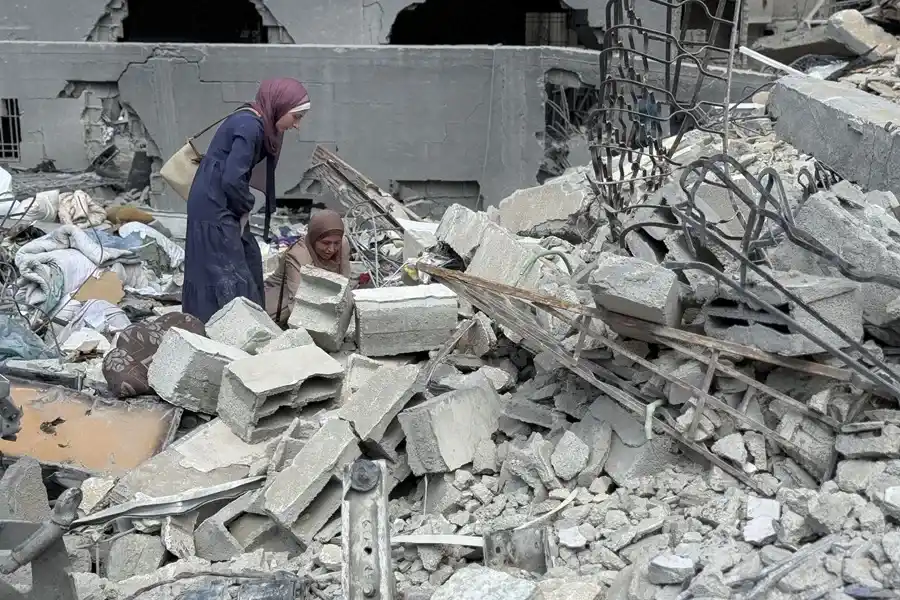 Mujeres gazatíes intentaban salvar algunas de sus pertenencias entre los escombros de la torre Al Jundi, en la ciudad de Gaza, derribada el domingo, por el Ejército israelí. EFE