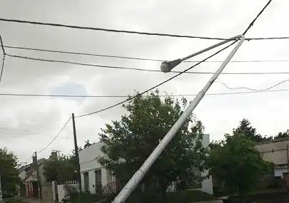 Un peligro, un palo de luz agarrado solo de los cables