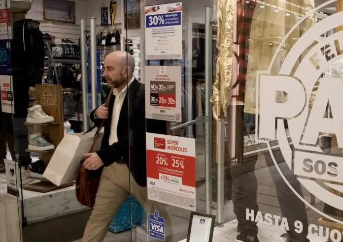 Un hombre saliendo de un local de venta de ropa masculina