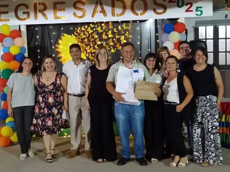 Toda la emoción del homenajeado, sosteniendo un obsequio junto a ex compañeros y colegas de otras escuelas.