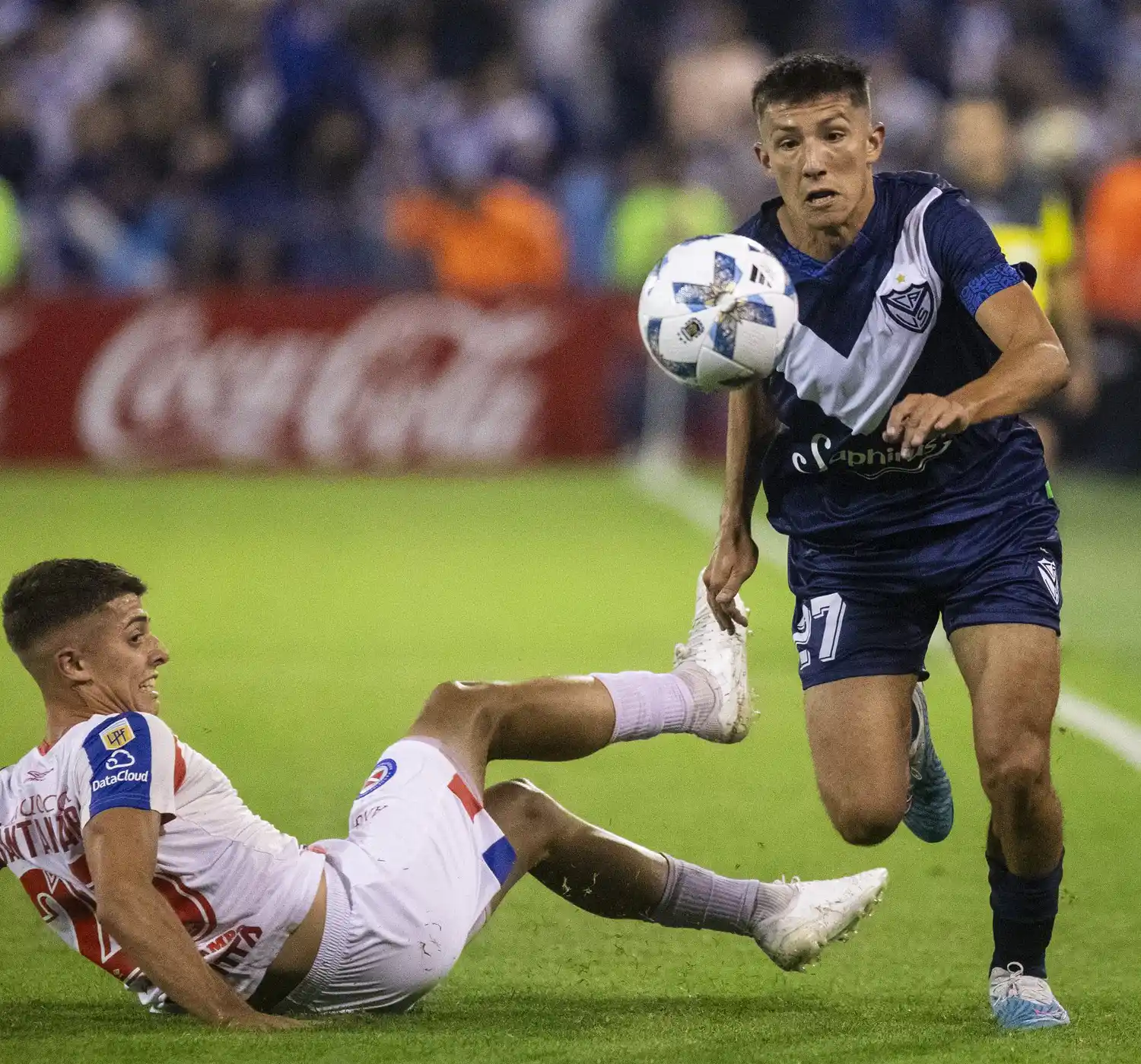 Desde el piso, Santamaría intenta frenar a Thiago Fernández.