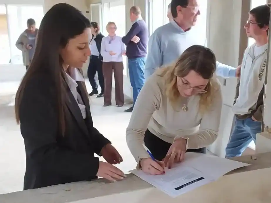 Junto al intendente Chalde, Sabrina Gabotto firmando la documentación que la reconoce como propietaria de la casa