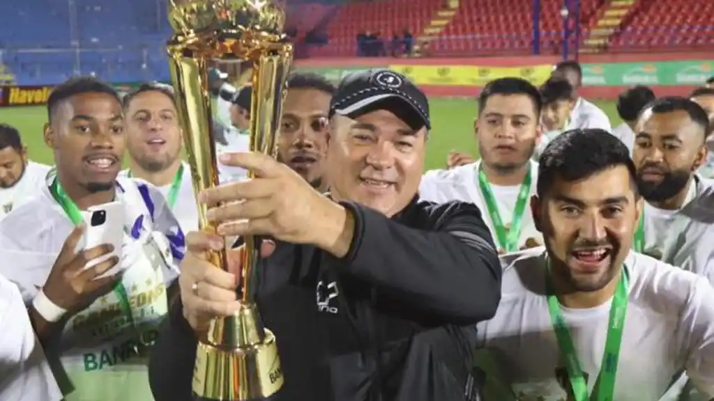 Tapia sostiene el trofeo del Apertura rodeado por sus dirigidos. (Foto de prensa Antigua).