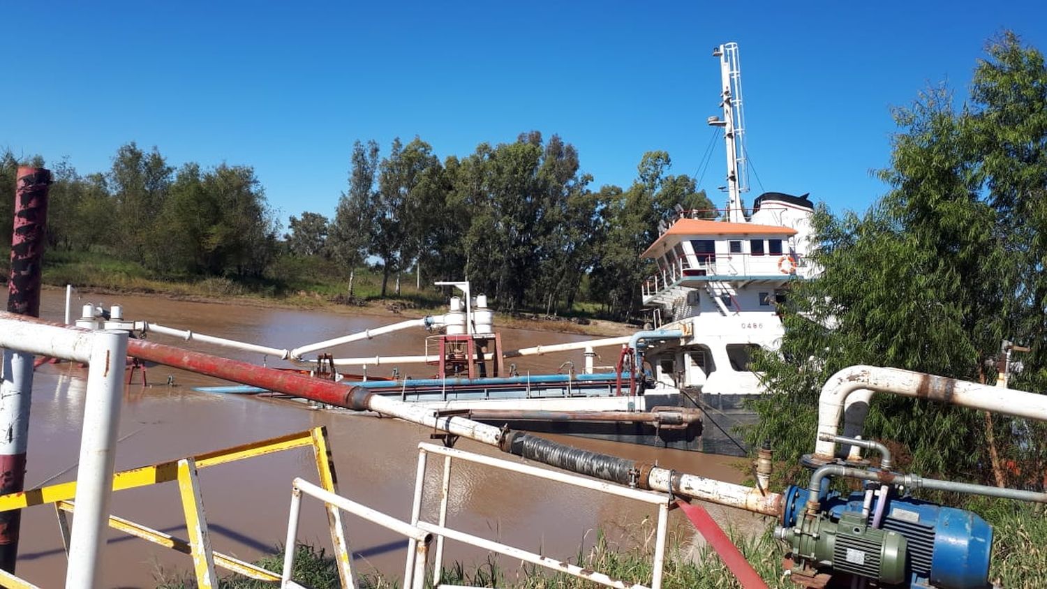 Barco arenero está en riesgo de hundimiento en el riacho y trabajan para rescatarlo
