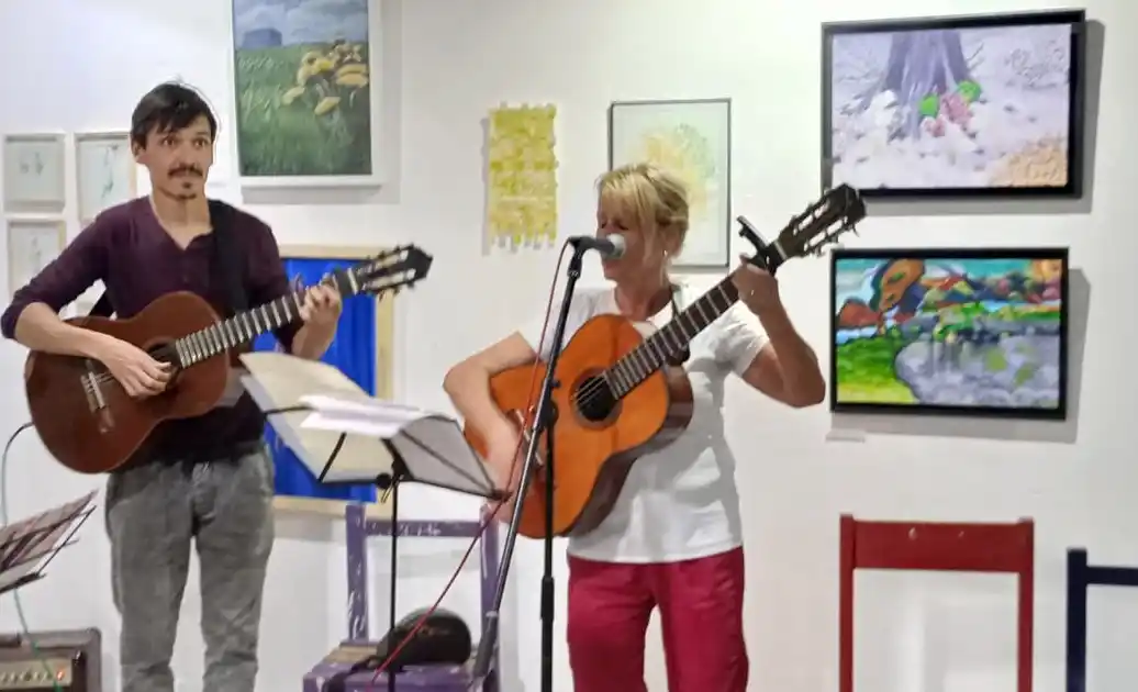 Presentación musical. El profesor Guido Arce acompaña a una alumna con la guitarra