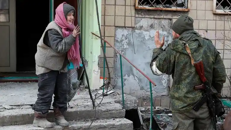 Una residente habla con un soldado de las tropas prorrusas en la ciudad portuaria sitiada del sur de Mariupol.