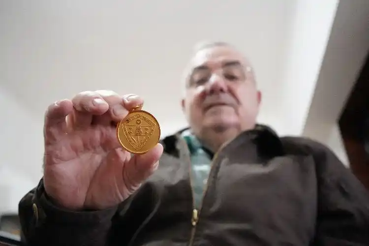 Vottero, coleccionista de medallas, enseñando una de sus piezas.