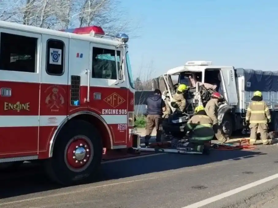 Personal de bomberos rescatando al chofer de la cabina.