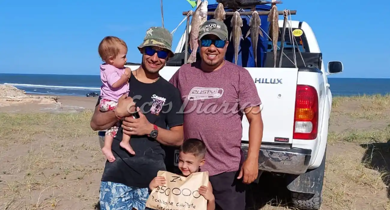 Alan posa con su premio, junto a su familia, con el sobre del primer puesto