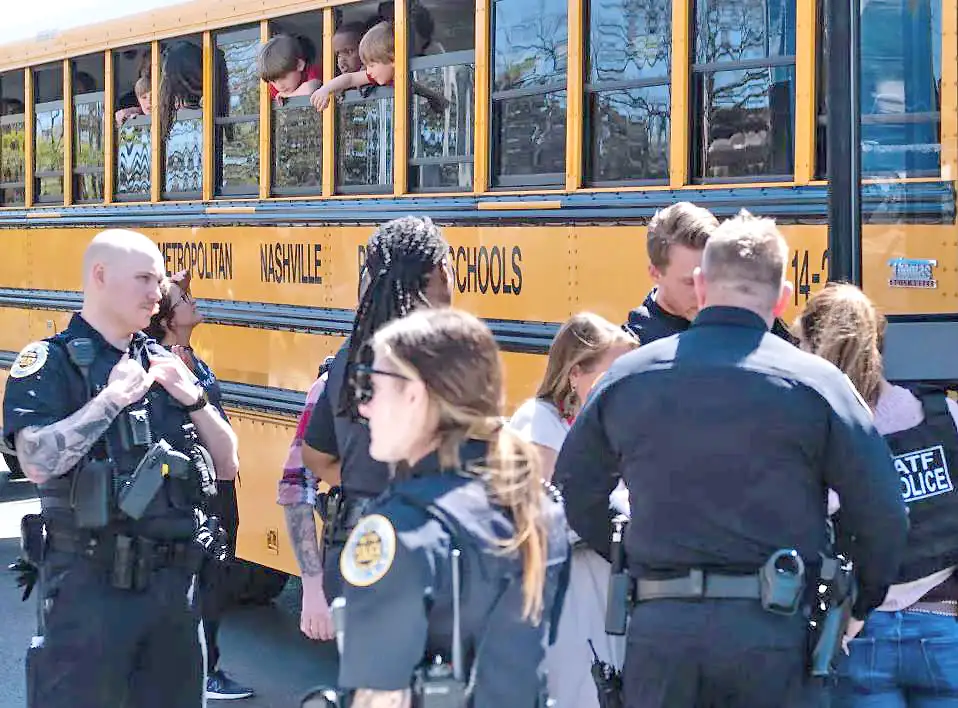 La policía y niños, luego del tiroteo en la escuela Covenant en Nashville.