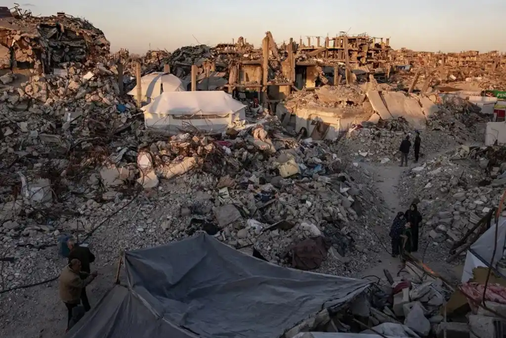 Palestinos caminan junto a edificios destruidos en el campo de refugiados de Yabalia, en el norte de la Franja de Gaza, en una imagen de archivo. EFE}