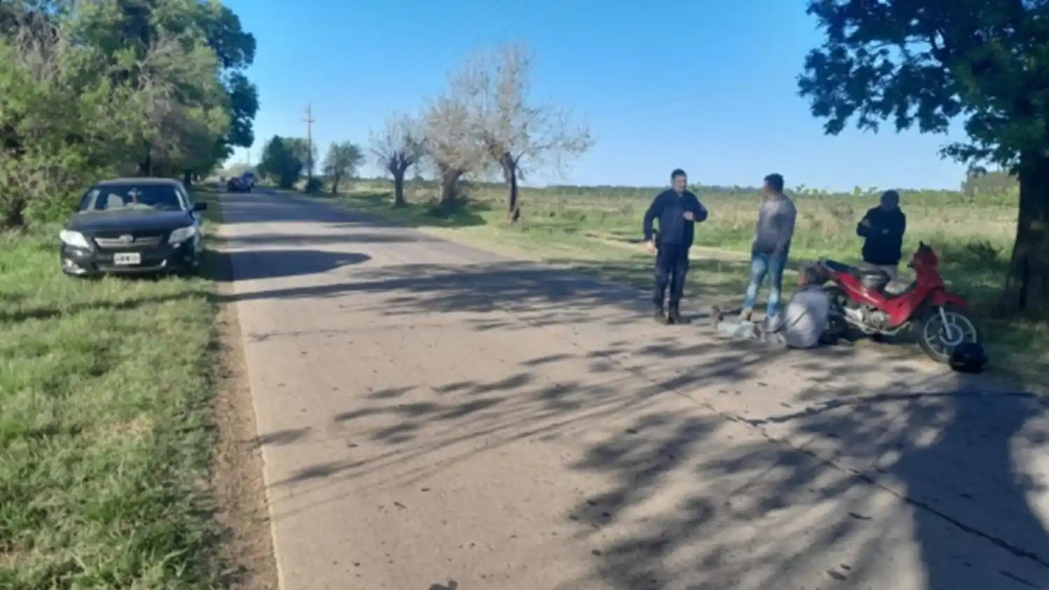 El conductor de la moto es asistido mientras aguarda la llegada de la ambulancia.