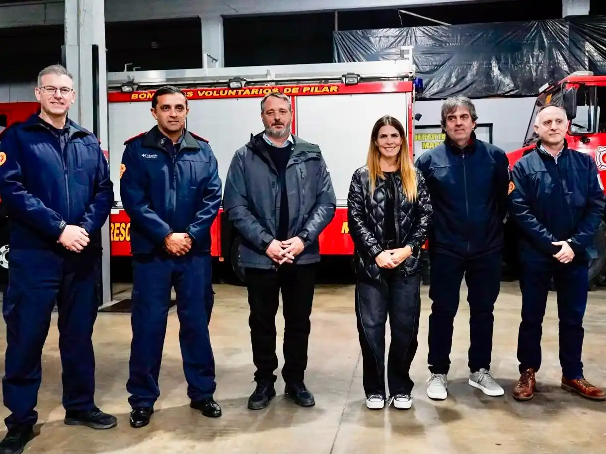 Peralta y Laurent posan junto a los responsables de Bomberos de Pilar