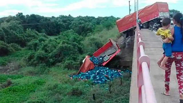 Camión con cerveza chocó, despistó, quedó colgado de un puente y lo saquearon