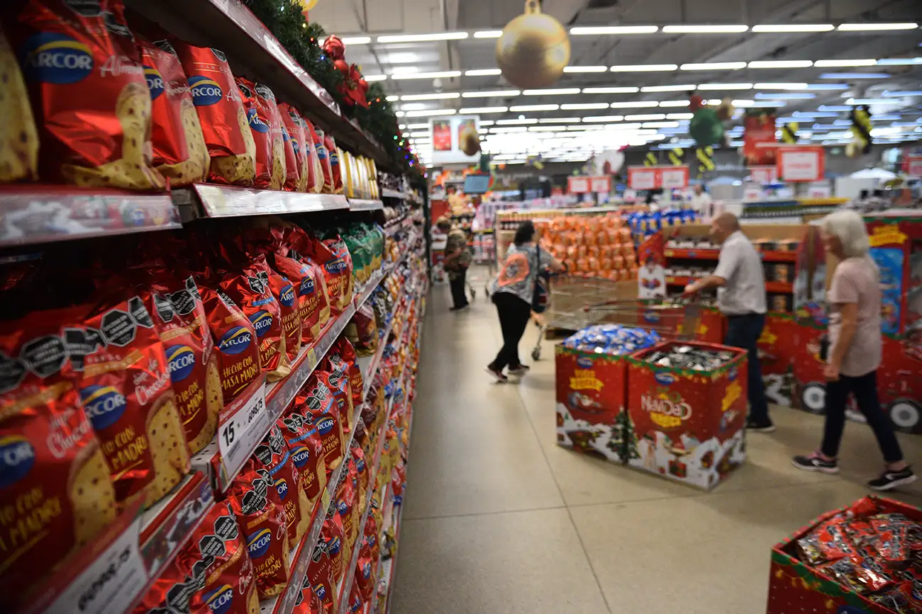 Los clientes pasan por las góndolas de productos navideños y miran los precios.