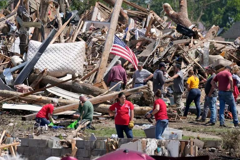 Residentes retiran los escombros de una casa dañada por un tornado, el miércoles 22 de mayo de 2024 en Greenfield, Iowa.