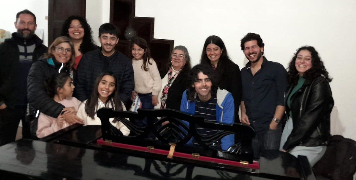 Docentes y alumnos junto al piano del Conservatorio-