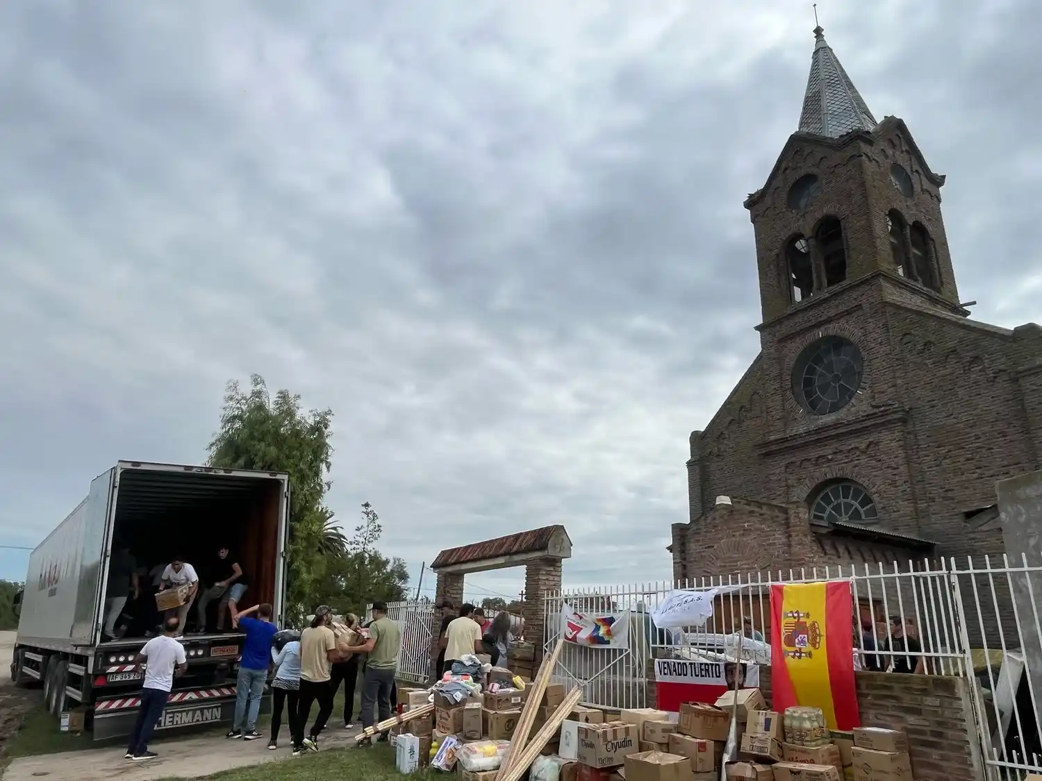 Voluntarios vendenses descargando los camiones con donaciones en Cerri.