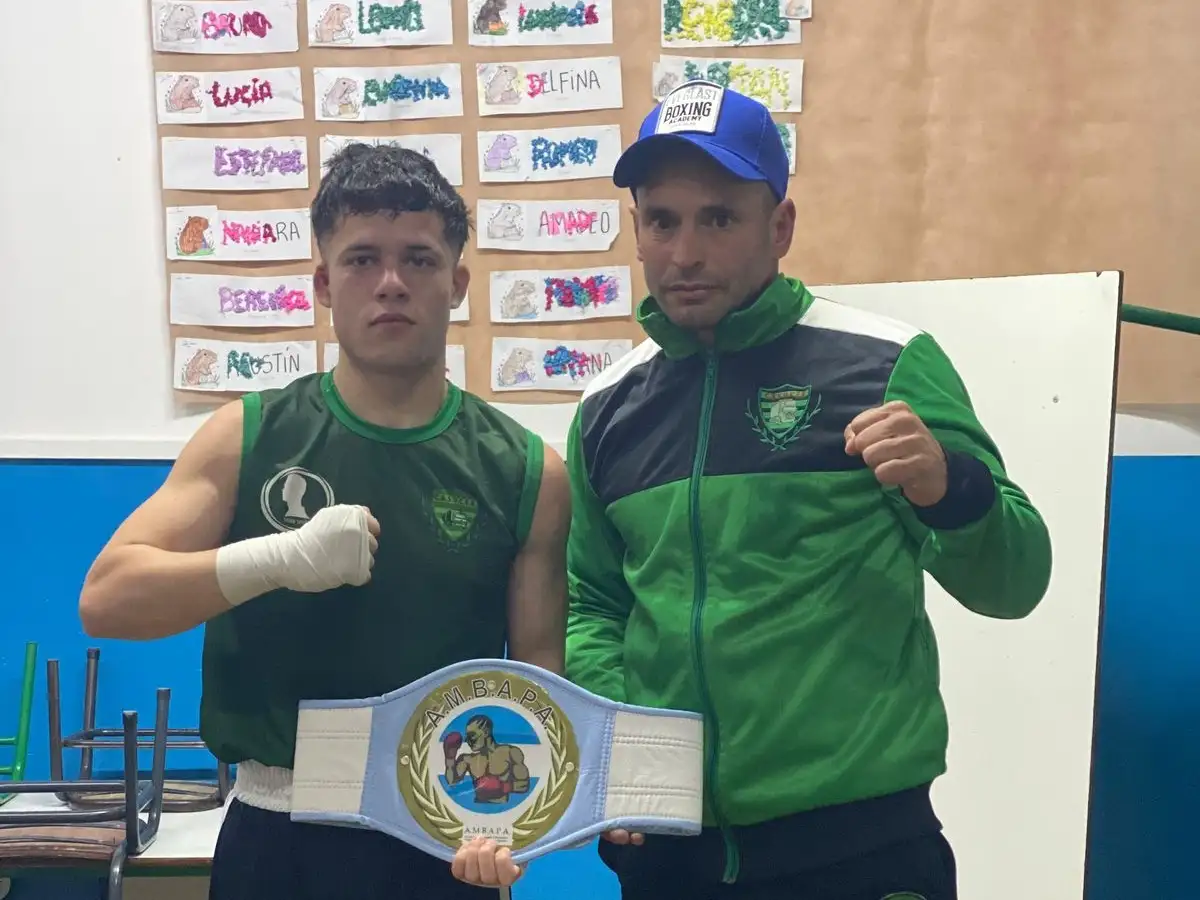Catriel Álvarez exhibe el cinturón de campeón junto a su entrenador Ángel Dulche.