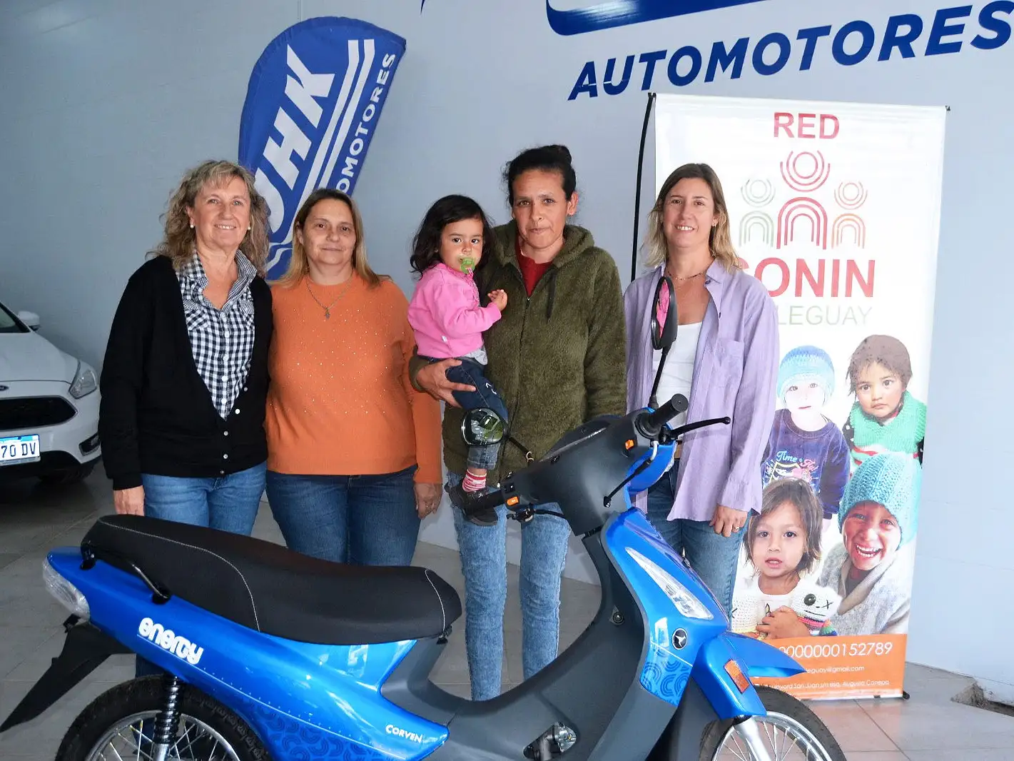 Integrantes de la Red Conin, la ganadora de la moto y la representante de JHK Automotores.
