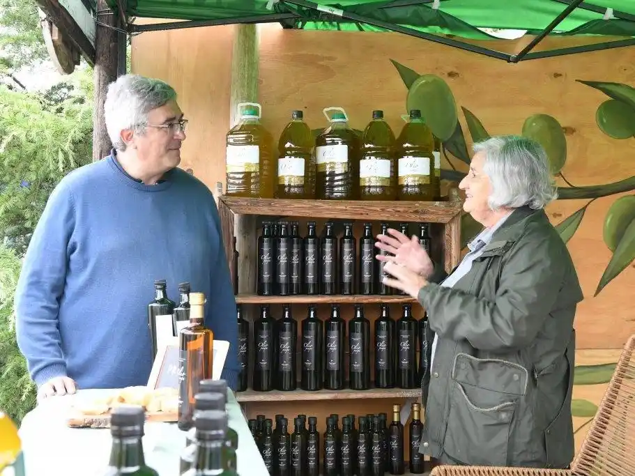 El ministro Rodríguez conversando con una productora olivícola dorreguense, en el Vivero Parque Municipal