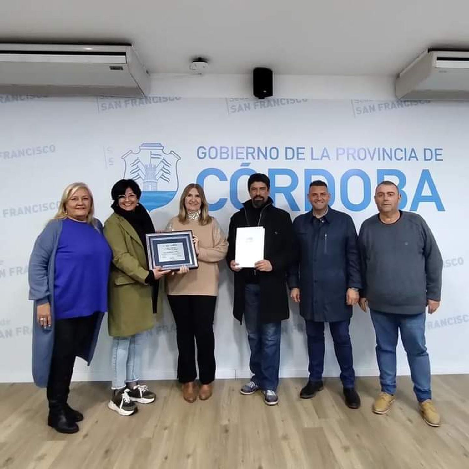 Alejandra Piasco entregando la distinción a miembros del Ballet Patria.