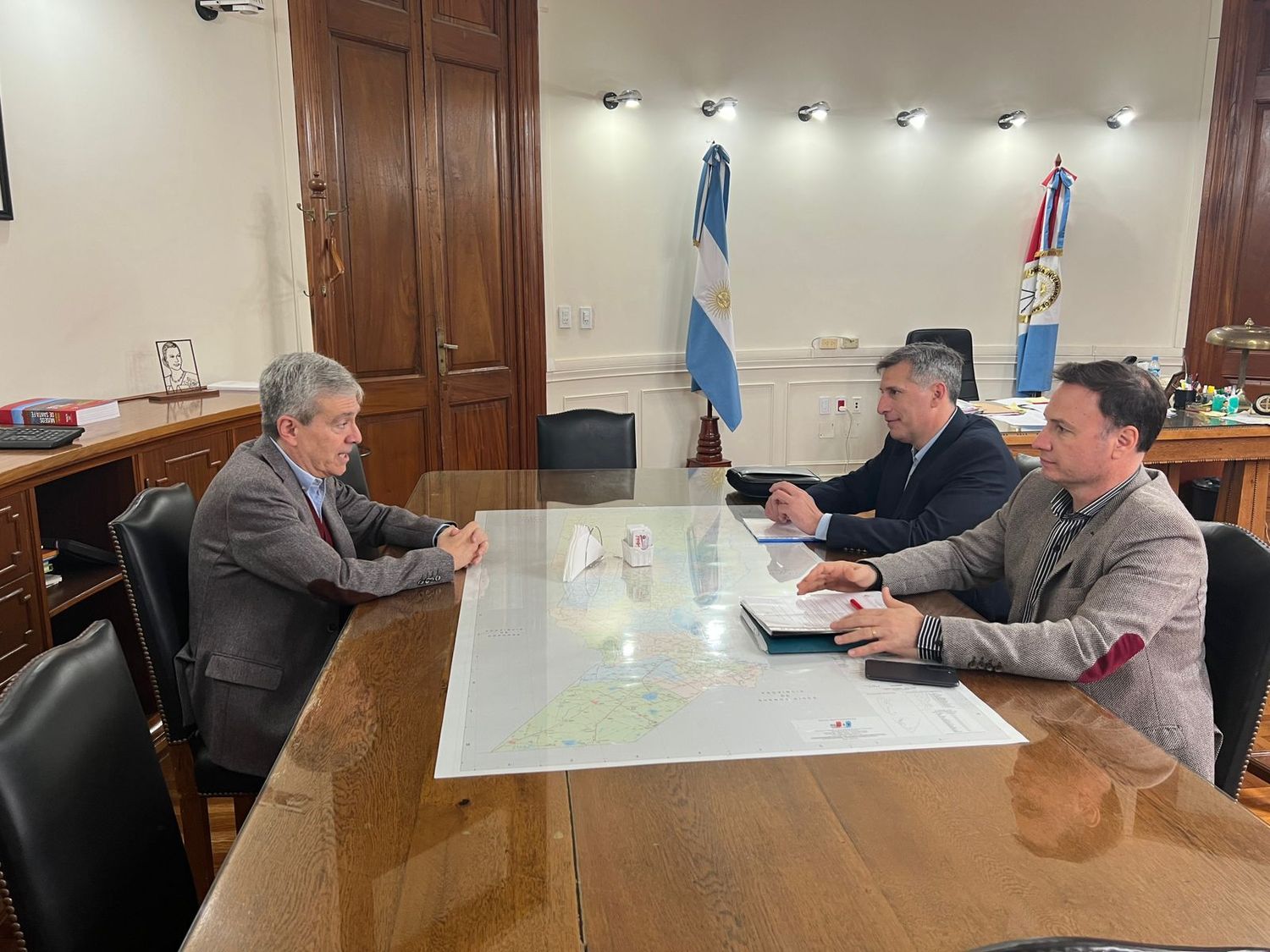 Pablo Olivares y Lisandro Enrico con el ministro Walter Agosto, en una de las reuniones de la transición. Crédito: Archivo El Litoral.