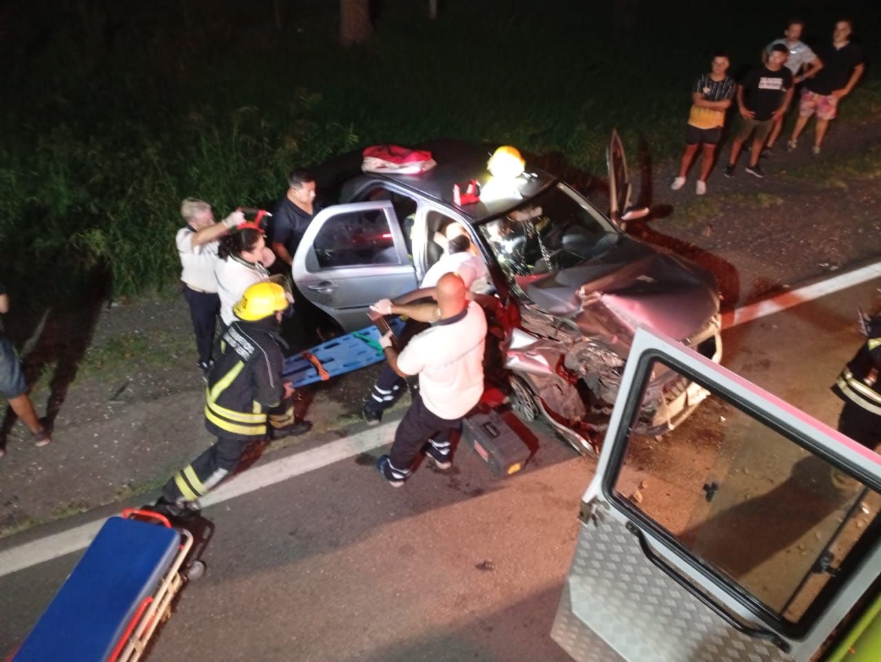 Personal de bomberos rescata a la mujer atrapada en el vehículo.