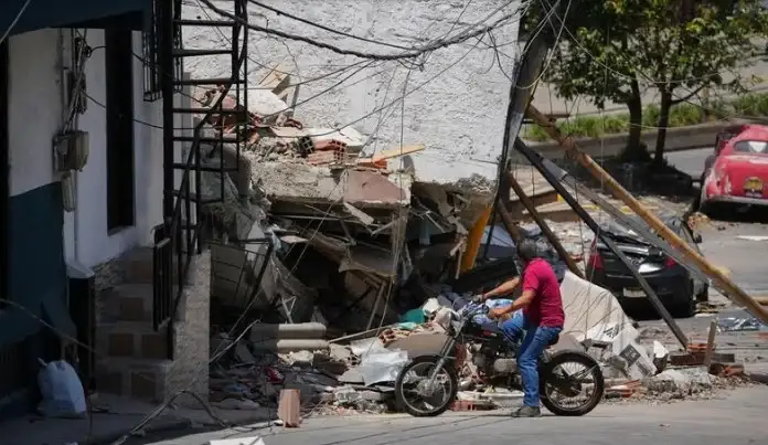 Un hombre observa los escombros de un edificio colapsado en Pereira, Colombia.