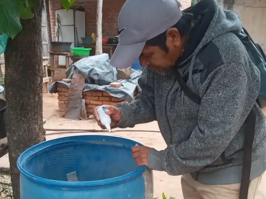 Un agente sanitario realiza tareas de prevención en Formosa aplicando larvicida en un tanque de agua para eliminar criaderos del mosquito transmisor del dengue tras las intensas lluvias registradas en la región.