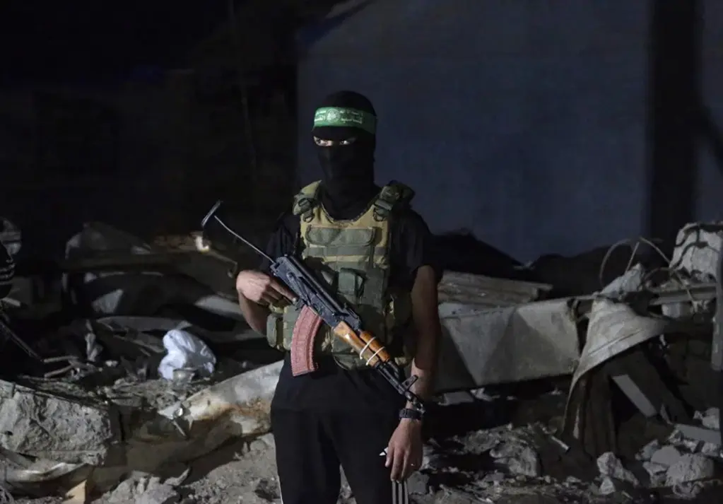 Combatientes palestinos de Hamás vigilan mientras llegan los restos de los rehenes israelíes entregados por Hamás. EFE
