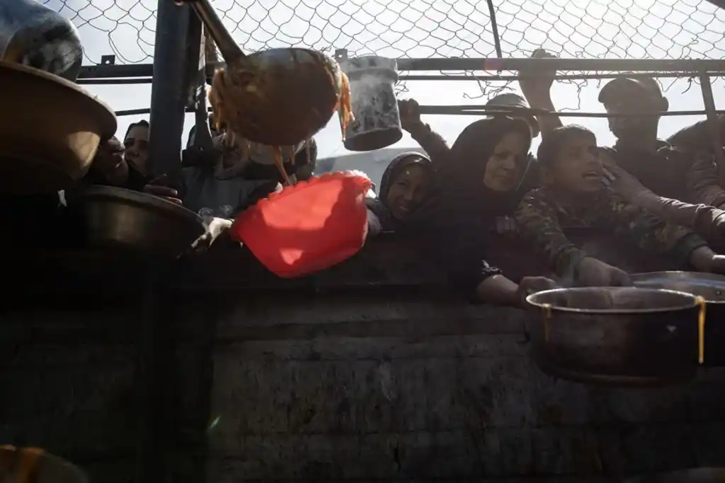 Palestinos incluidos niños, se reúnen para recibir alimentos, en Khan Yunis, al sur de la Franja de Gaza. EFE