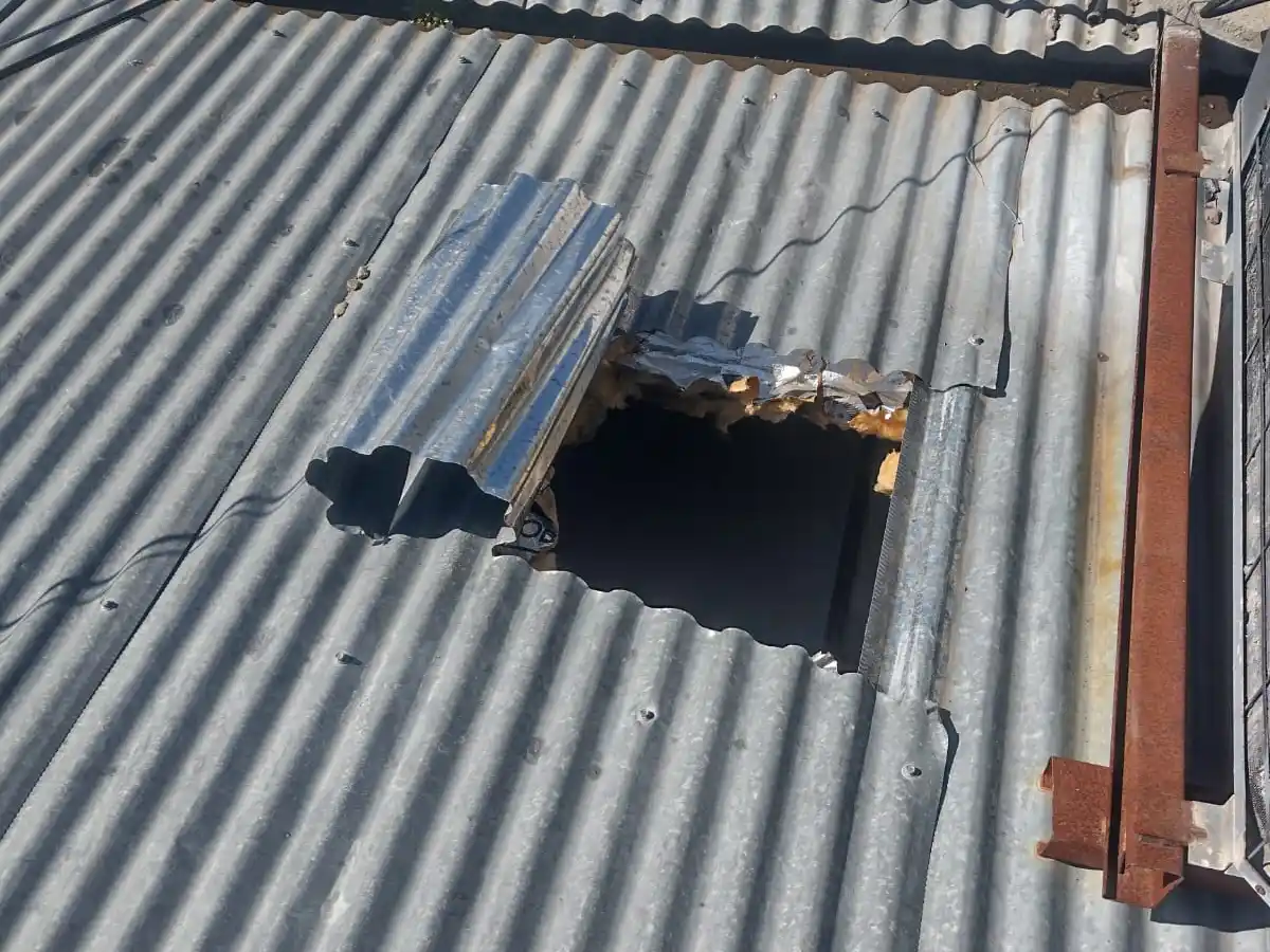 Uno de los tres agujeros que realizaron en las chapas del techo.