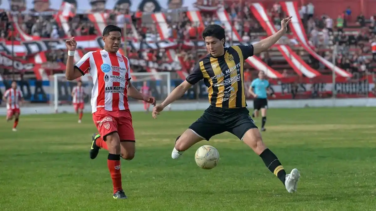 Adriano Romero intenta controlar la pelota ante el asedio de Rivarola. (Foto gentileza de Diario Uno, de Mendoza).