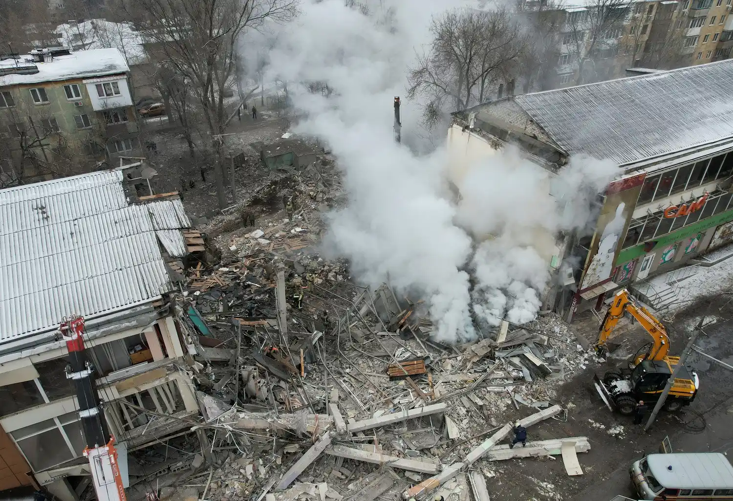 Personal de emergencia trabaja entre los escombros del edificio destruido en los recientes bombardeos.