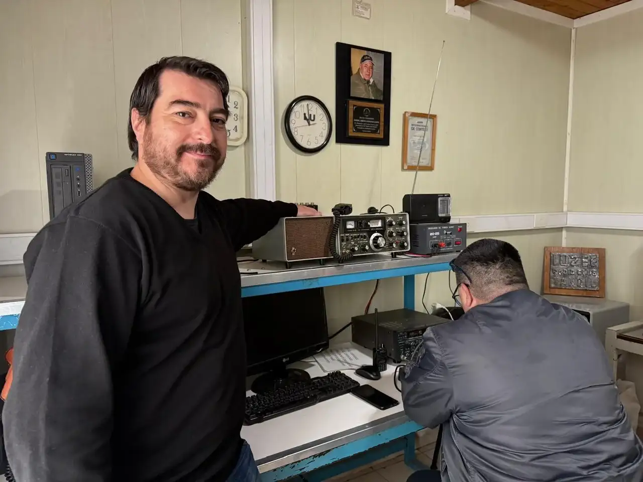 Fotografía de integrantes del Radio Club Tandil, en su nueva sede. Con equipos de radio aficionados.