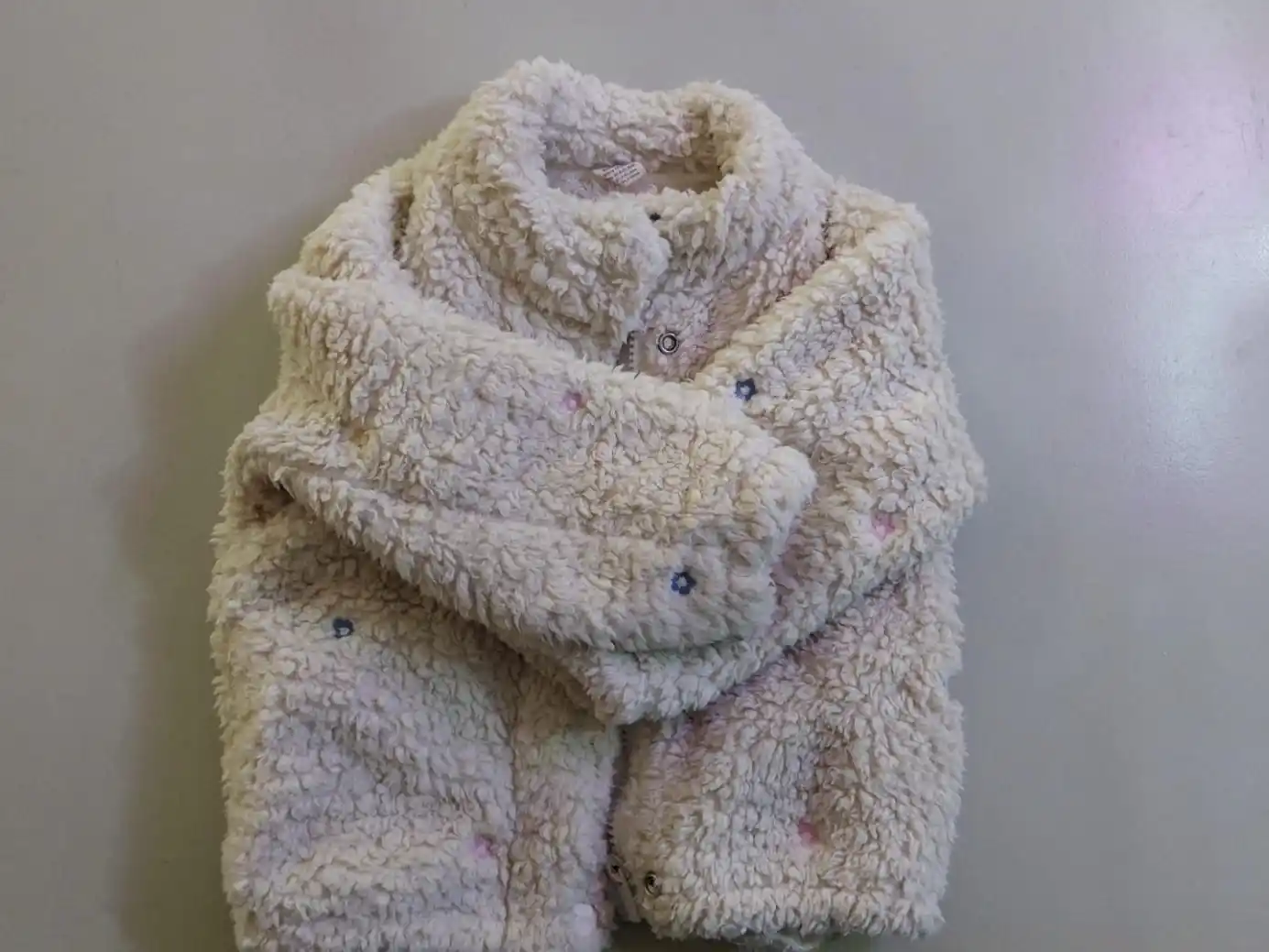 Hallaron campera de niña color beige con flores en la calle
