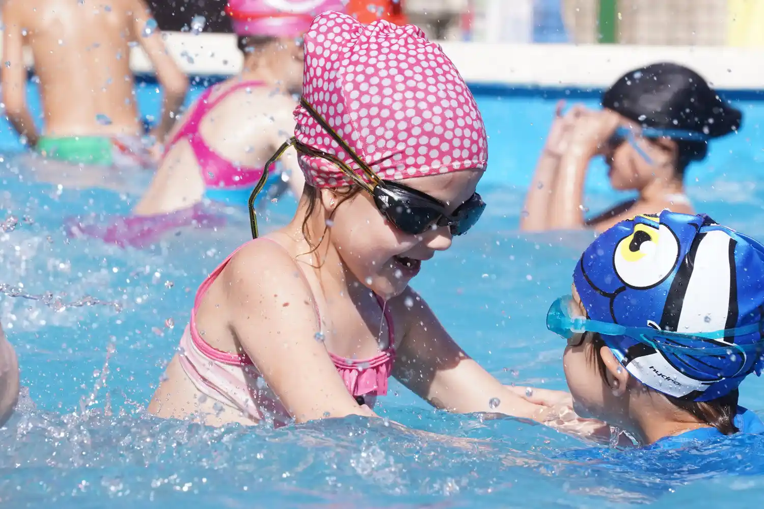 Niños disfrutan actividades recreativas en el agua.