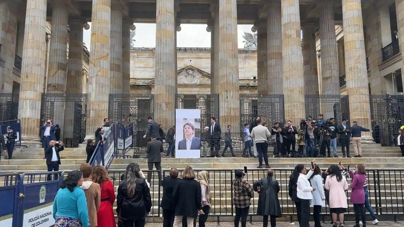 Ciudadanos y medios de comunicación se reúnen en la entrada del Congreso de la República para rendir homenaje póstumo al senador Miguel Uribe Turbay.