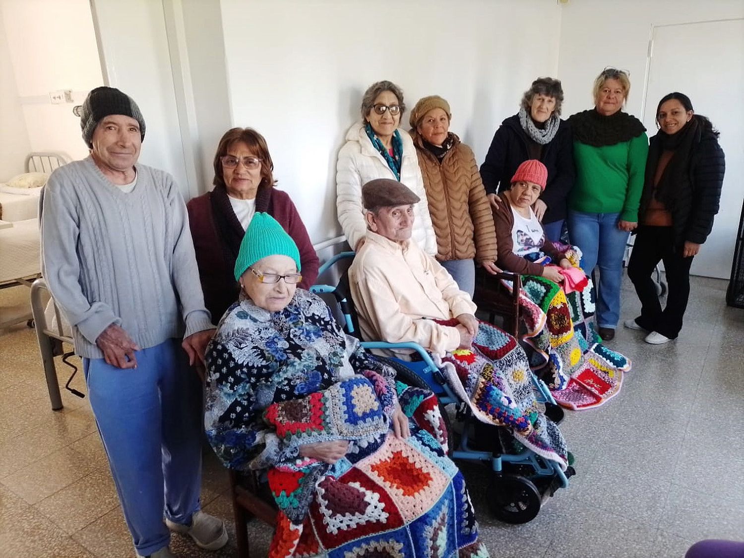 Integrantes de "Las arañitas tejedoras" junto a abuelos del geriátrico.