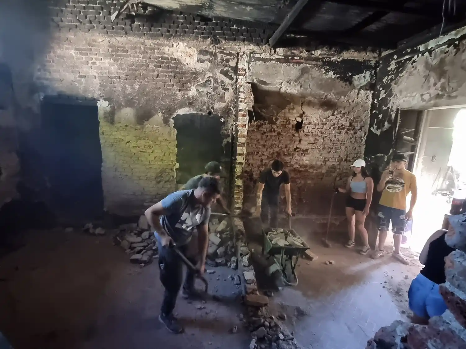 Amigos de la familia trabajan en el interior de la casa para remover los escombros tras el incendio.
