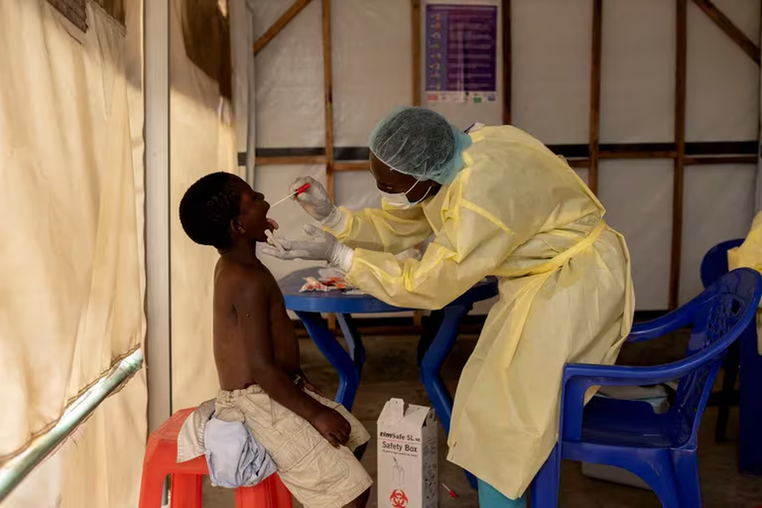 Christian Musema, enfermero de laboratorio, toma una muestra de un niño declarado caso sospechoso de Mpox