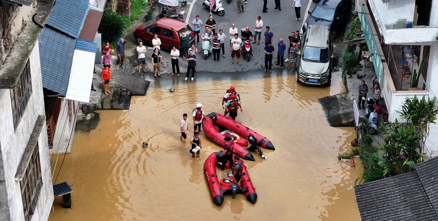 Rescatistas ayudando a residentes a cruzar el agua de la inundación, en el distrito de Rong'an, en la región autónoma de la etnia zhuang de Guangxi, en el sur de China. Crédito: Xinhua/Tan Kaixing