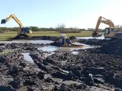 Una retroexcavadora municipal lleva días sumergida en el arroyo Peralta