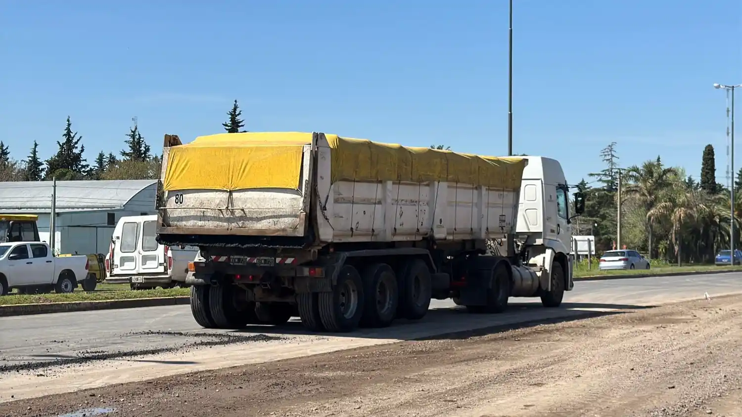Los camiones areneros circulan por la recientemente repavimentada ruta 1001.