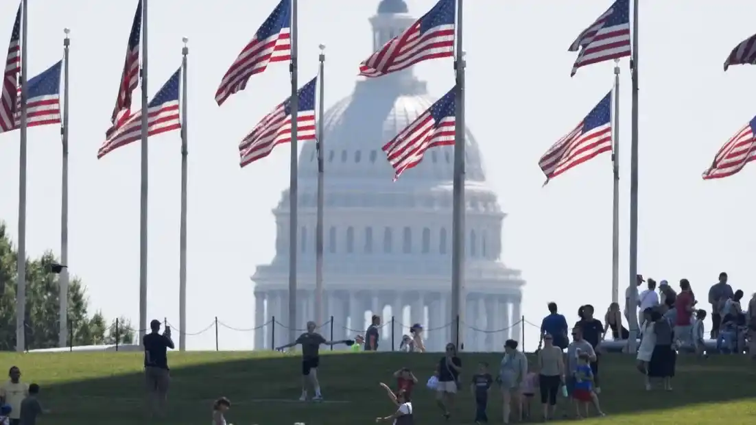 El Capitolio de Estados Unidos, en Washington D.C., con banderas estadounidenses en primer plano.