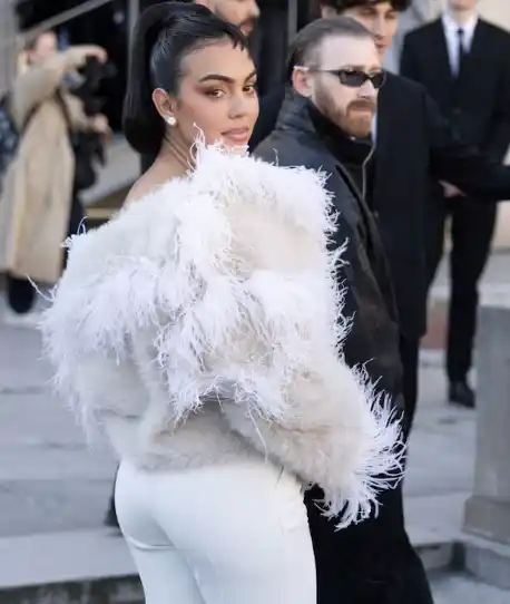 Con un abrigo de plumas blanco y un inédito flequillo corto, Georgina impactó en el desfile de Elie Saab