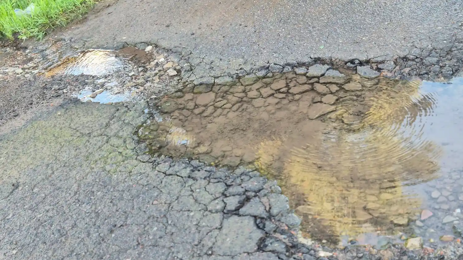 El bache ocupa casi toda la calzada en Urraco al 500. Además, presenta una pérdida de agua.