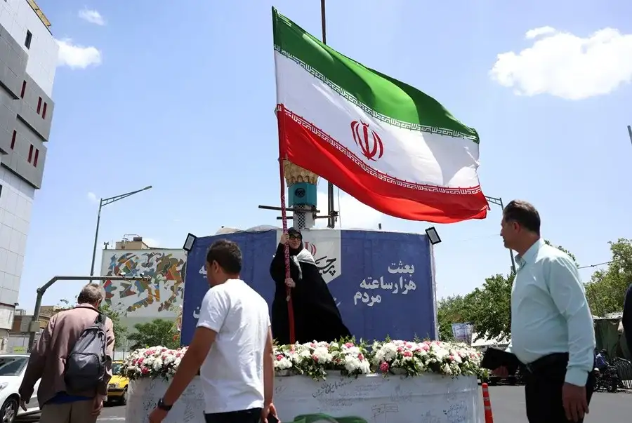 Personas caminan frente a una bandera de Irán en una calle de Teherán. EFE